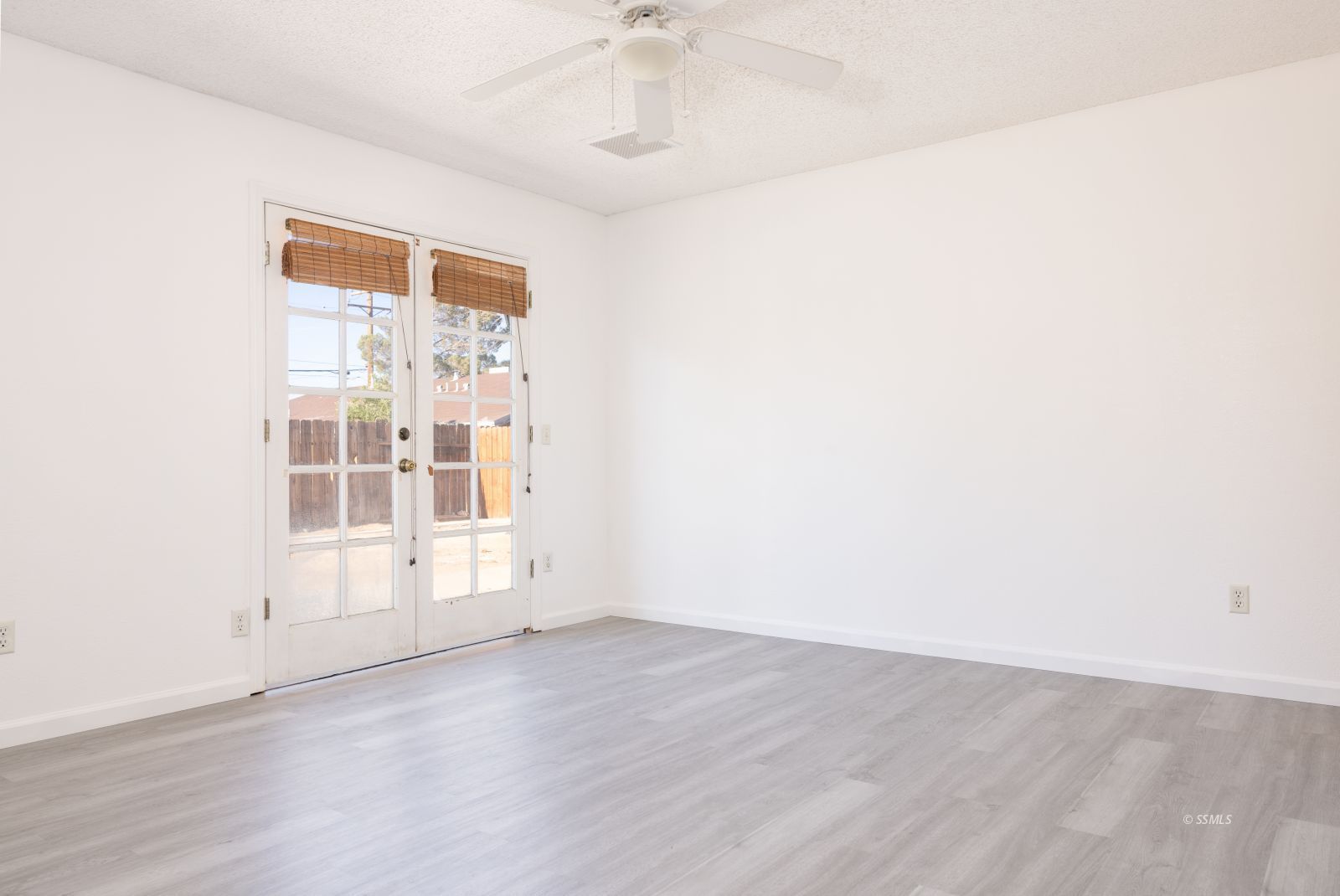 820 Walker Lane Ridgecrest, CA 93555 - Photo 22 of 27 an empty room with wooden floor fan and windows