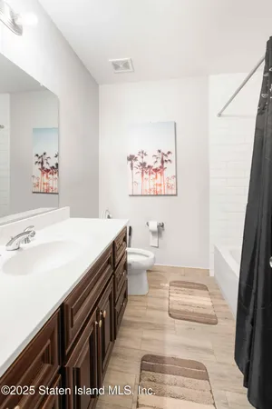 a spacious bathroom with a tub sink and a large mirror
