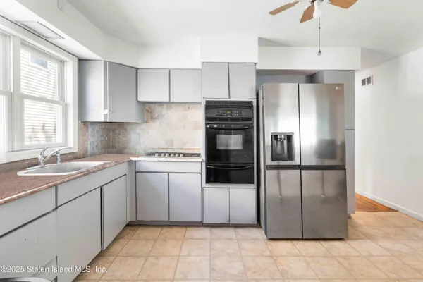 a kitchen with kitchen island granite countertop a refrigerator oven a sink and dishwasher