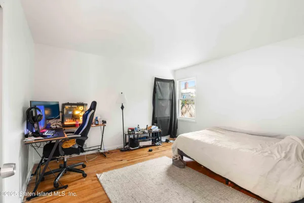 a bedroom with bed desk and a window