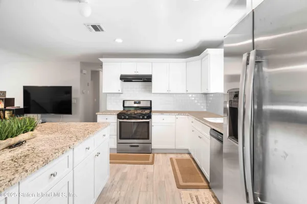 a large kitchen with a stove a sink and a refrigerator