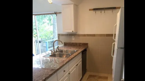 a kitchen with a sink a refrigerator and window