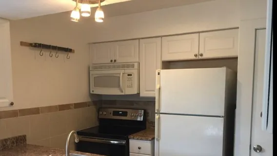 a white refrigerator freezer and a stove sitting inside of a kitchen