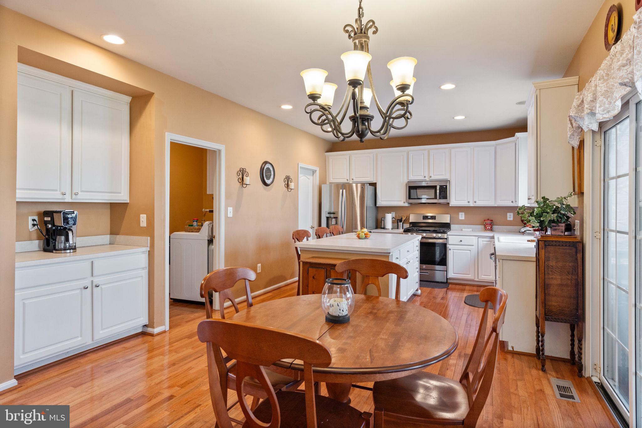 12298 Wake Forest Road Clarksville, MD 21029 - Photo 11 of 46 a view of a dining room with furniture a kitchen and chandelier
