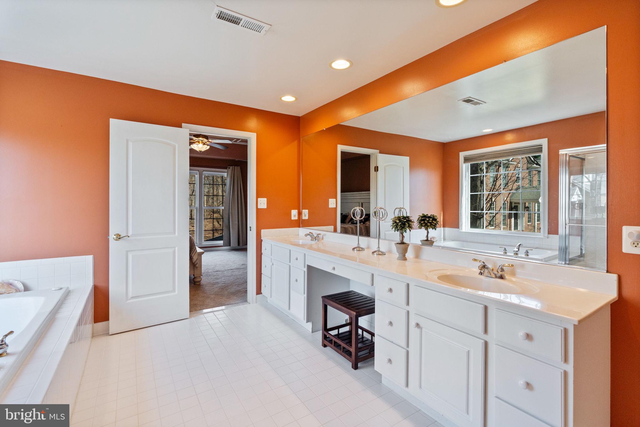 12298 Wake Forest Road Clarksville, MD 21029 - Photo 21 of 46 a spacious bathroom with a sink double vanity granite tub shower and mirror