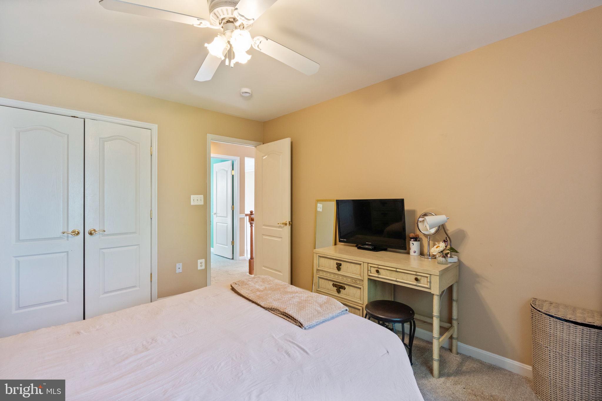 12298 Wake Forest Road Clarksville, MD 21029 - Photo 27 of 46 a bedroom with a bed tv and a chandelier