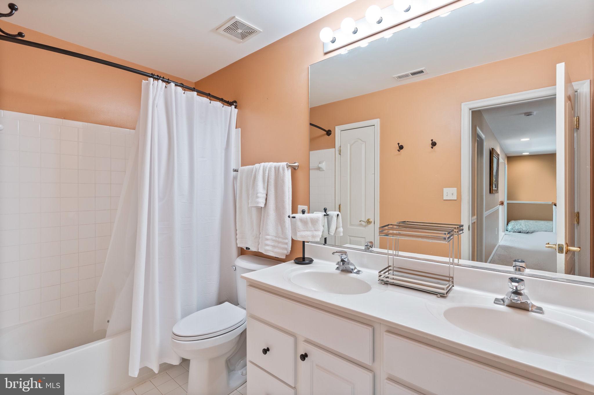 12298 Wake Forest Road Clarksville, MD 21029 - Photo 30 of 46 a bathroom with a double vanity sink toilet and a mirror