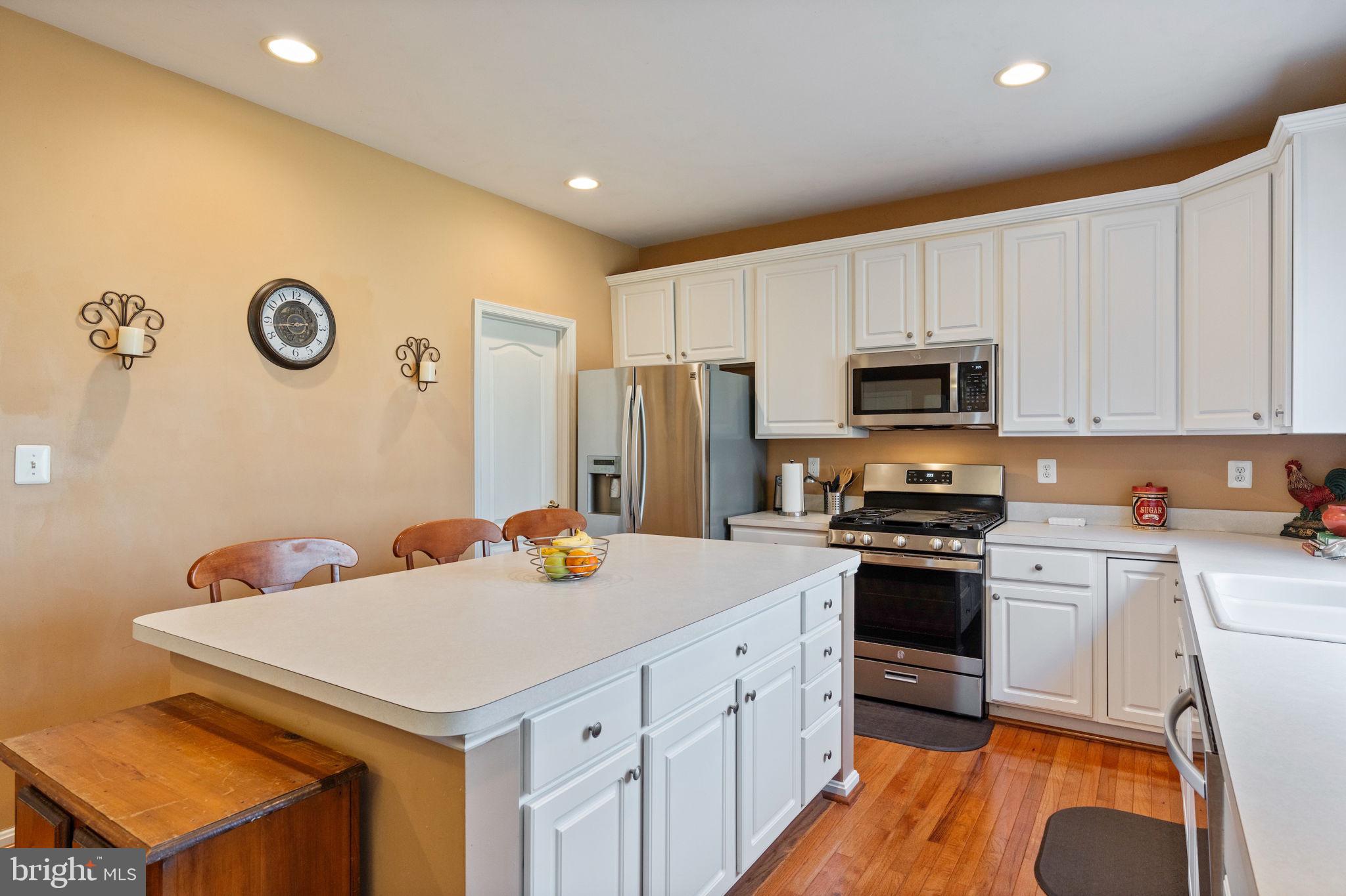 12298 Wake Forest Road Clarksville, MD 21029 - Photo 8 of 46 a kitchen with stainless steel appliances a stove a sink a microwave a refrigerator a stove and white cabinets