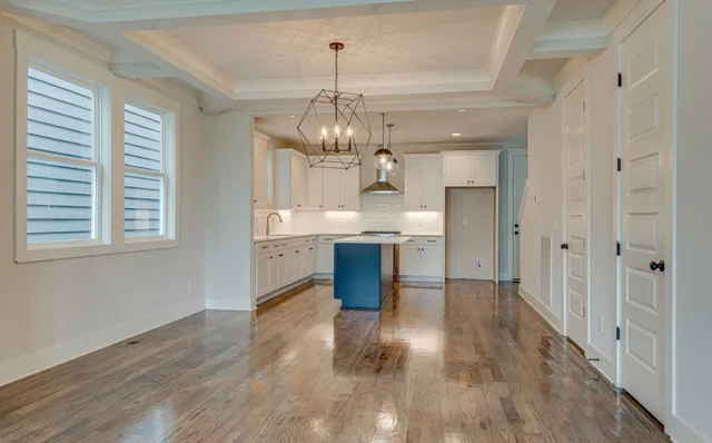 a large kitchen with chandelier and wooden floor