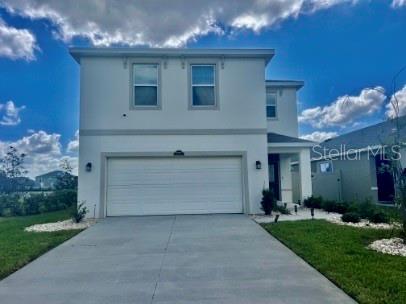 31284 Penny Surf Loop Wesley Chapel, FL 33545 - Photo 2 of 15 a front view of a house with a yard and a garage
