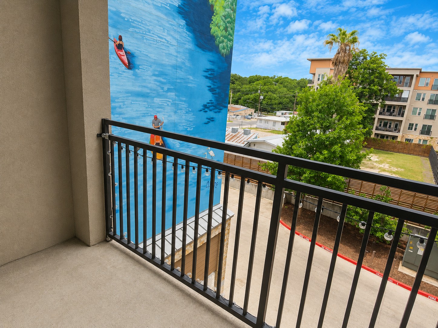 1900 Barton Springs Road, Unit 3036 Austin, TX 78704 - Photo 8 of 19 An outward view from the patio featuring a vibrant mural. Garage entry below allows you to open the garage access from your balacony for guests