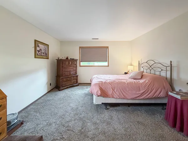 a spacious bedroom with a bed and a cabinets