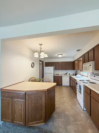 a large white kitchen with a stove top oven a sink and dishwasher