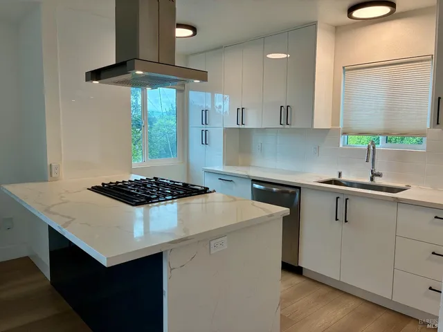 a kitchen with stainless steel appliances granite countertop a stove a sink and a microwave