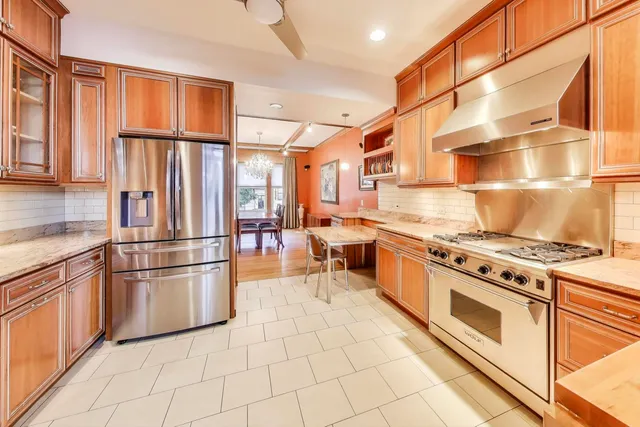a kitchen with stainless steel appliances granite countertop a stove a refrigerator and a refrigerator