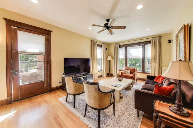 a living room with furniture a flat screen tv and a large window