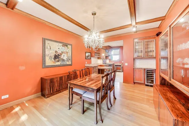a dining room with furniture a chandelier and wooden floor
