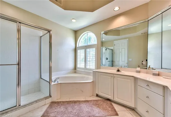 a spacious bathroom with a double vanity sink a mirror and a bathtub