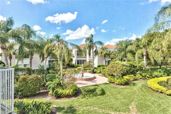 a view of a fountain in a yard with potted plants