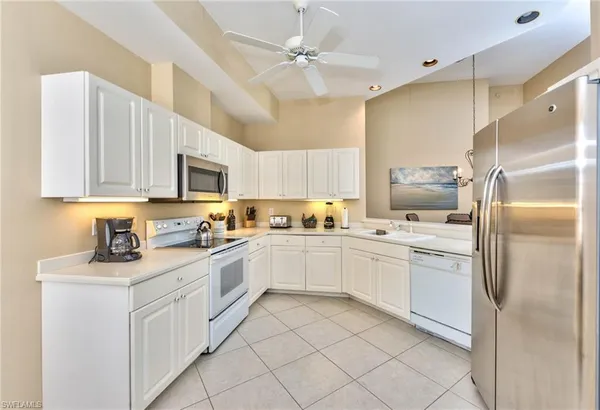 a kitchen with white cabinets stainless steel appliances and a refrigerator