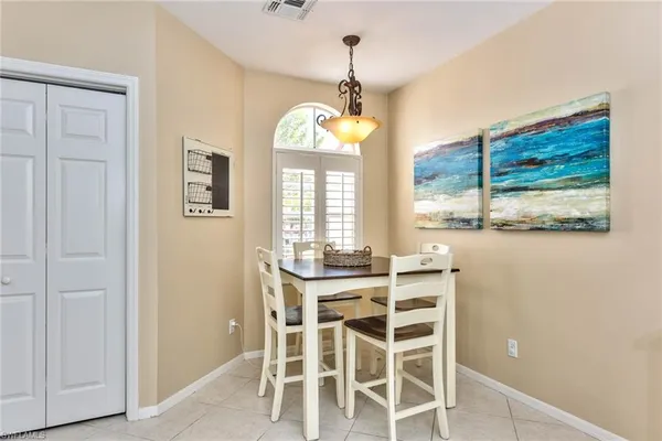 a dining room with furniture a chandelier and window