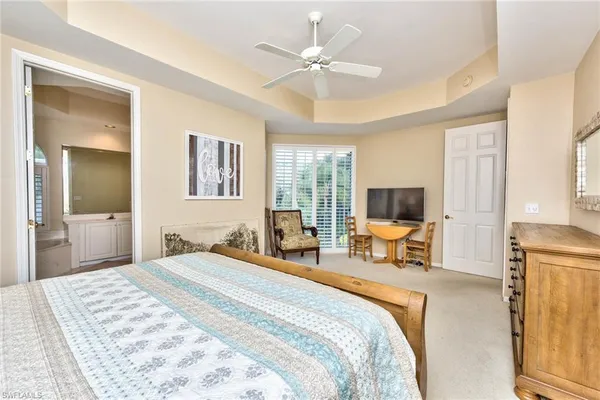 a bedroom with a bed a large window and a flat screen tv