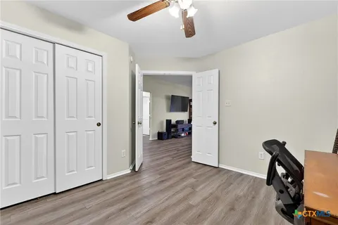 a view of a hallway with wooden floor and closet