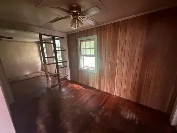 en empty room with windows and ceiling fan