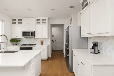 a kitchen with stainless steel appliances a stove refrigerator sink and microwave