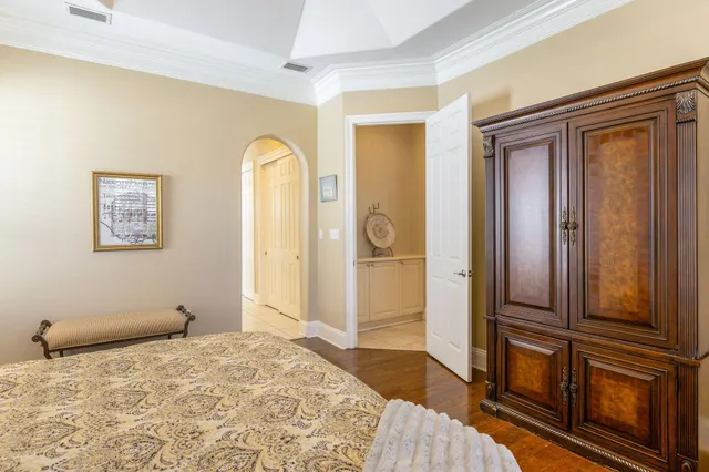 a bedroom with a bed and wooden floor