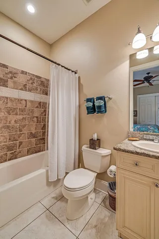 a bathroom with a granite countertop toilet sink and mirror