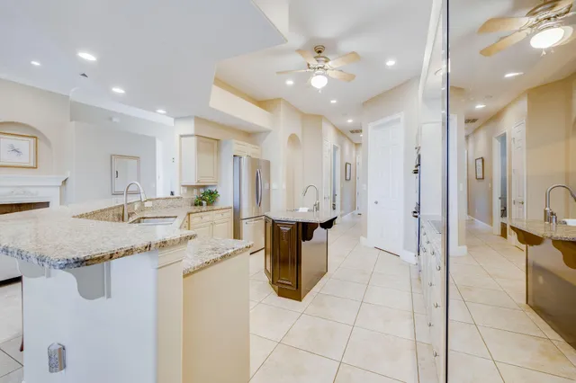 a large kitchen with stainless steel appliances kitchen island granite countertop a large counter top and a view of living room