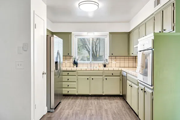 a kitchen with a sink cabinets stainless steel appliances and windows