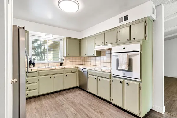 a kitchen with white cabinets and sink