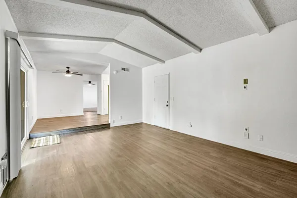 a view of an empty room with wooden floor