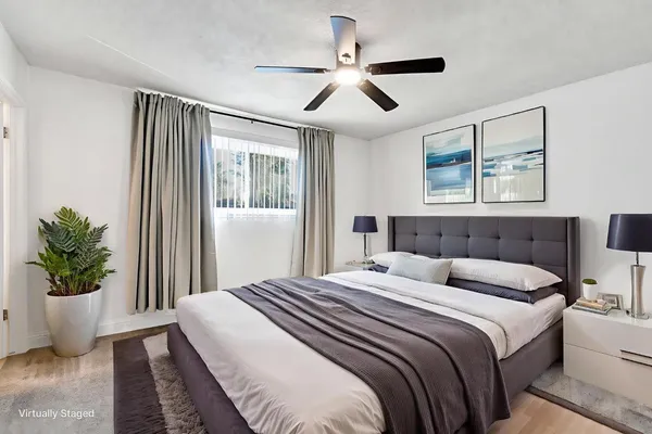 a bedroom with a large bed and a potted plant