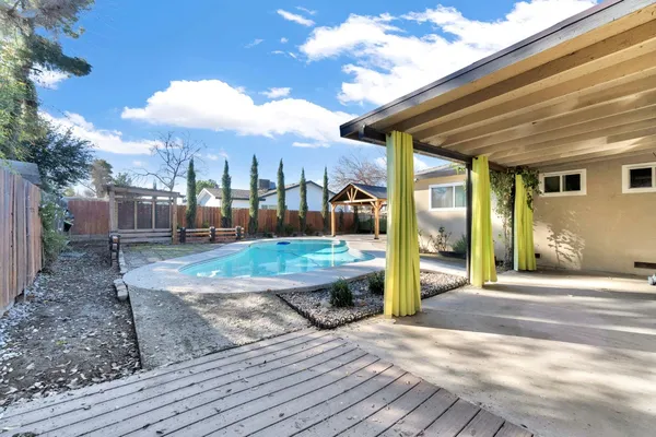 a view of a house with backyard and sitting area