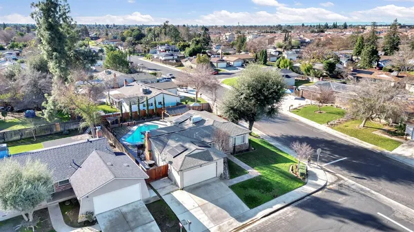 an aerial view of a house with a yard and lake view