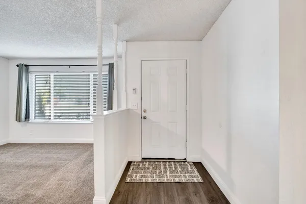 a view of an empty room with a fireplace and a window