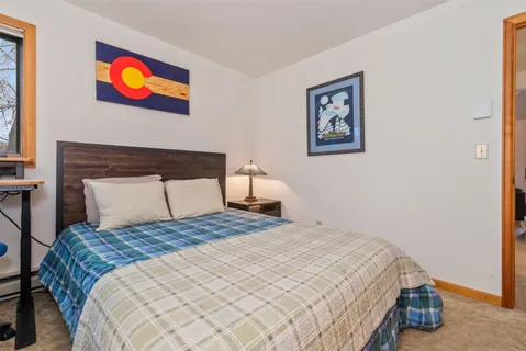 a bedroom with a bed and painting on the wall