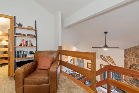 a living room with furniture a rug and a book shelf