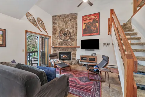 a living room with furniture a flat screen tv and a fireplace