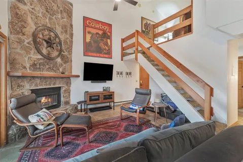 a living room with furniture a flat screen tv and a fireplace