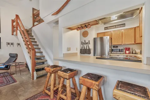 a view of a kitchen with furniture and staircase