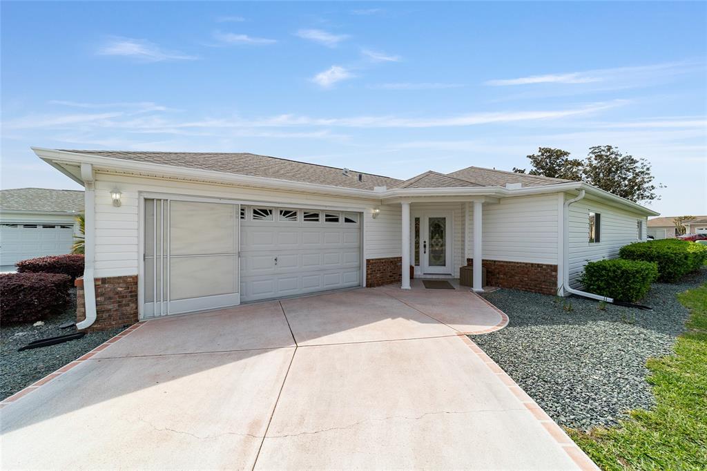 8608 Southeast 141st Street Road Summerfield, FL 34491 - Photo 2 of 82 a front view of a house with a yard and garage