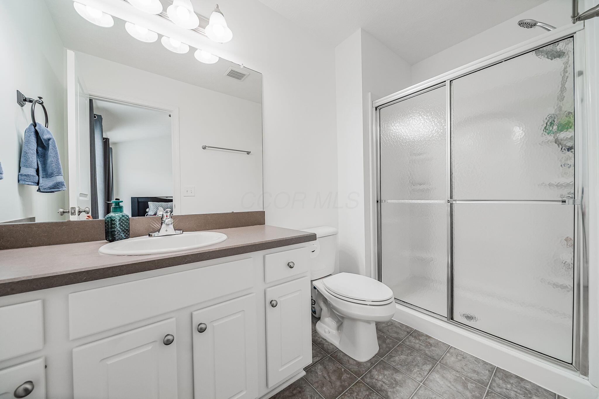 6186 Needletail Road, Unit 66 Columbus, OH 43230 - Photo 18 of 48 Bedroom #1 en-suite bathroom with oversized vanity, easy-to-care-for flooring, and netural decor.