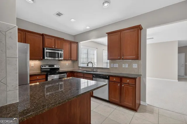 a kitchen with stainless steel appliances granite countertop a sink counter space cabinets and a sink