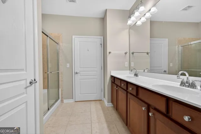 a bathroom with a double vanity sink a mirror and a shower