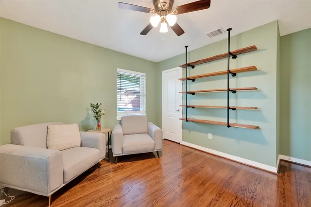 a living room with furniture and a ceiling fan