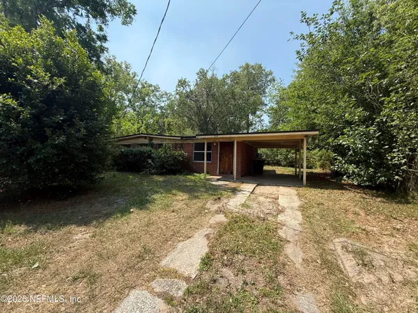 a front view of a house with a yard and trees